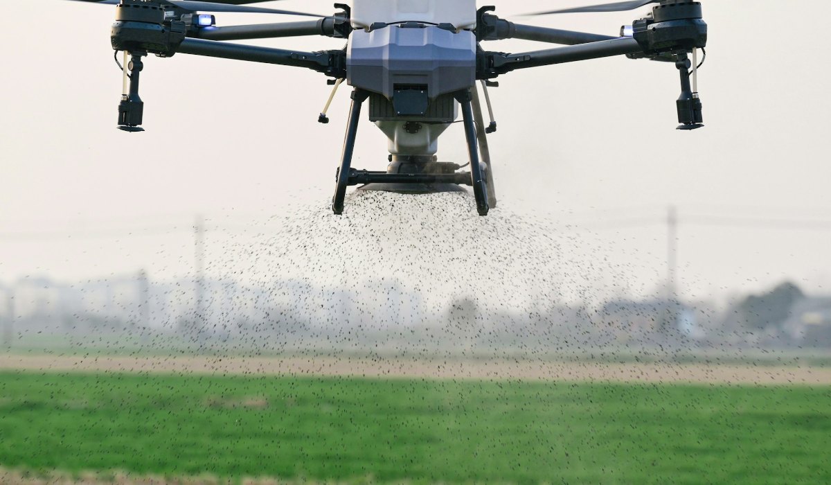 Agricultural drone spreading granular fertilizer over a field, an aircraft already in service and unaffected by the FCC rules